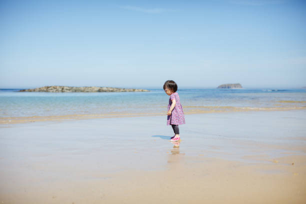 istock baby girl playing at summer beach 1007486046
