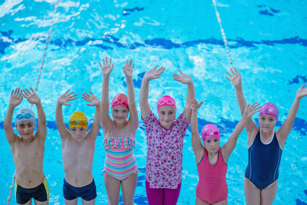 istock happy children kids group at swimming pool class learning to swim 1007488672