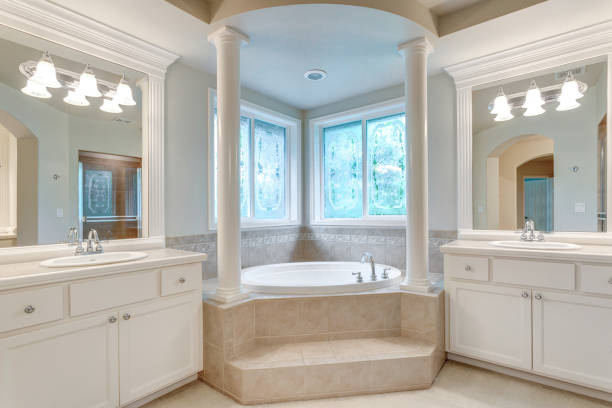 istock Luxury master bathroom with corner tub under stained-glass windows. 1007496666