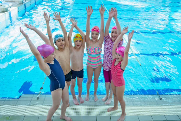 istock happy children kids group at swimming pool class learning to swim 1007498248