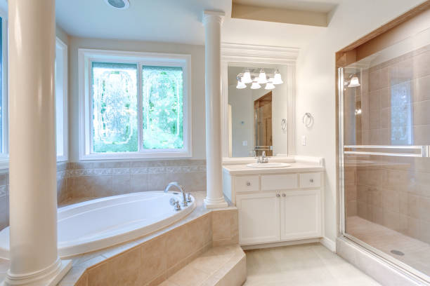 istock Luxury master bathroom with corner tub under stained-glass windows. 1007498392