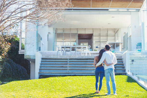 istock Young Couple standing in front of a modern new house. 1007514082