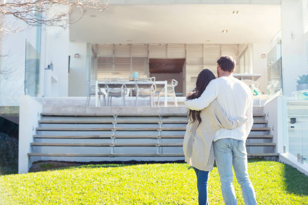 istock Young Couple standing in front of a modern new house. 1007514094