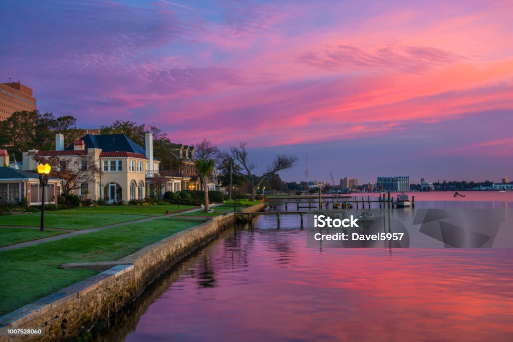 Portsmouth, Virginia Houses And Riverfront At Dawn Houses and Riverfront of the Elizabeth River in Portsmouth, Virginia during dawn with magenta, purple, and pink clouds.  Portsmouth, VA is part of the Virginia Beach / Hampton Roads metropolitan area. Virginia - US State Stock Photo