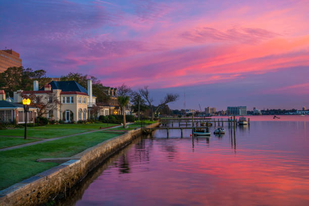 Portsmouth, Virginia Houses And Riverfront At Dawn Houses and Riverfront of the Elizabeth River in Portsmouth, Virginia during dawn with magenta, purple, and pink clouds.  Portsmouth, VA is part of the Virginia Beach / Hampton Roads metropolitan area. hampton virginia stock pictures, royalty-free photos & images