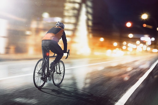 Cyclist rides through illuminated city