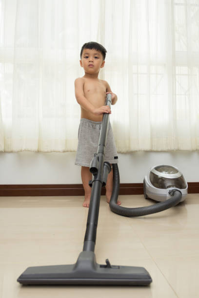 istock boy is cleaning the floor with a vacuum cleaner 1007580162