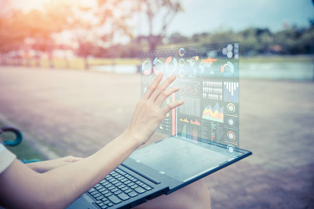 istock Businesswoman hand using advance technology computer hologram air screen display projection business information data chart outdoor for decision support system 1007587790