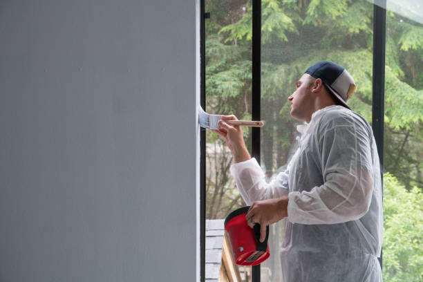 istock Man painting interior of home by window 1007590236