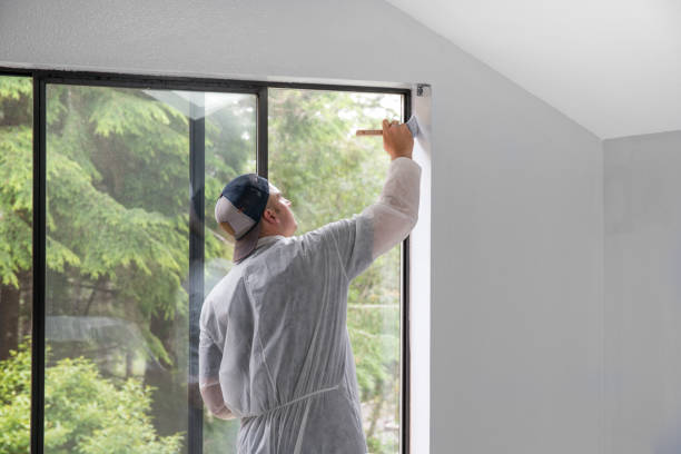 istock Man painting interior of home by window 1007593864