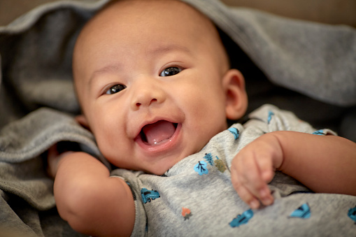 Cute 3 month old baby boy smiling with shallow depth of field