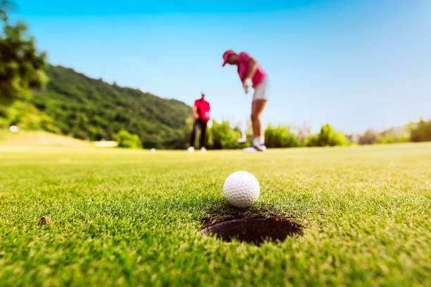 istock Golfer focus putting golf ball into the hole. 1007605106