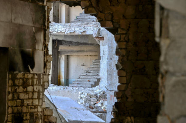 istock View from inside through the broken wall to the next destroyed building with a bare flight of stairs 1007610890