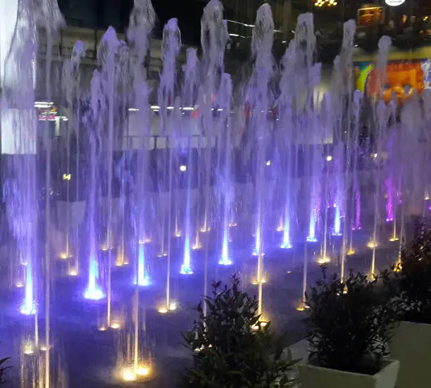 Colourful illuminated light fountain at night at shopping centre in Bangkok, Thailand