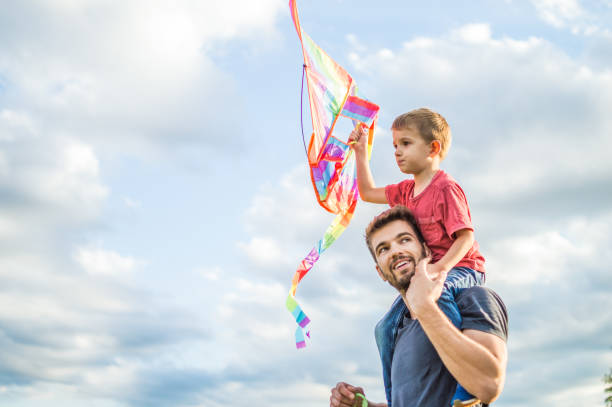 istock Little boy flying a kite with his father 1007618684