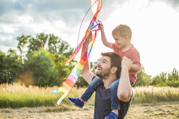 istock Little boy flying a kite with his father 1007618864