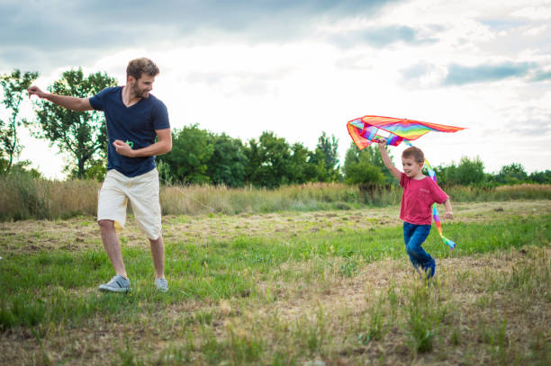 istock Little boy flying a kite with his father 1007619326
