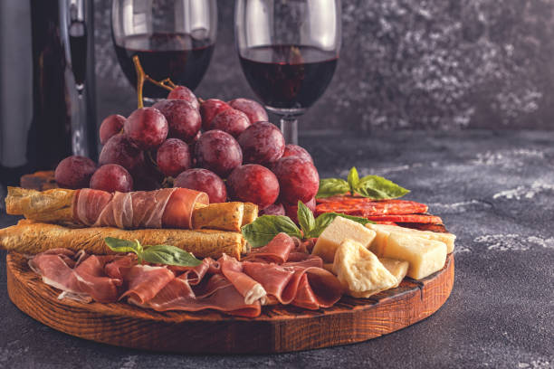 istock Prosciutto, sausage, wine, grape, parmesan on dark table 1007624838