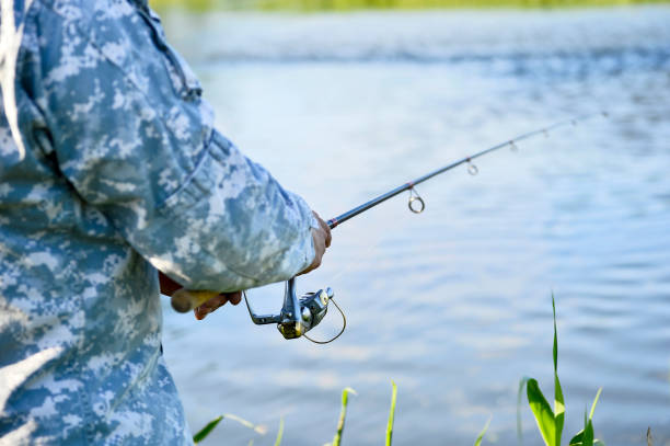 fisherman catching predatory fish spinning in the summer. rear and side view of the fishing reel in close-up. background - fishers of men flash imagens e fotografias de stock