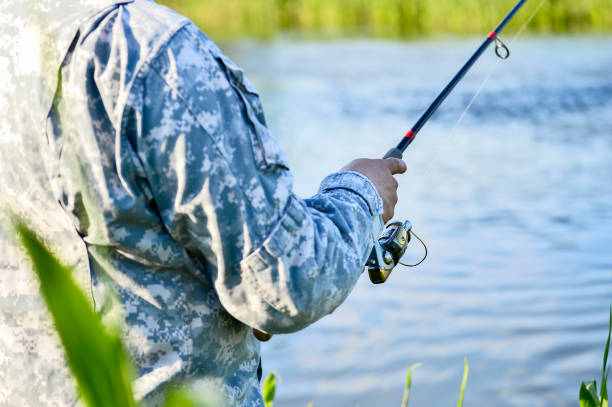 fisherman catching predatory fish spinning in the summer. rear and side view of the fishing reel in close-up. background - fishers of men flash imagens e fotografias de stock