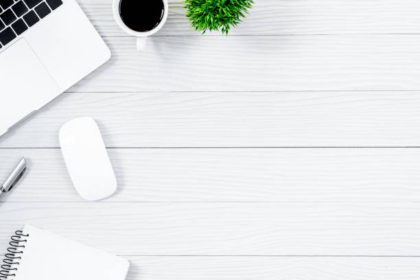 istock White wood office desk table and equipment for working with black coffee  in top view and flat ray concept. 1007632922