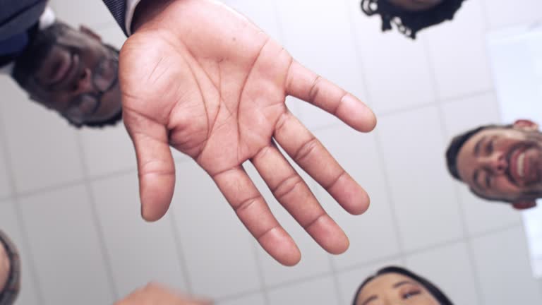 4k video footage of a group of businesspeople joining their hands in a modern office