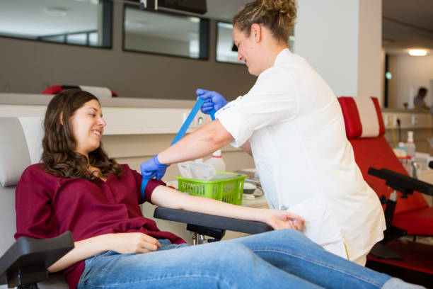young woman get prepared by a nurse for blood donation stock photo