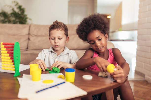 Cute little children mould from plasticine on table at home