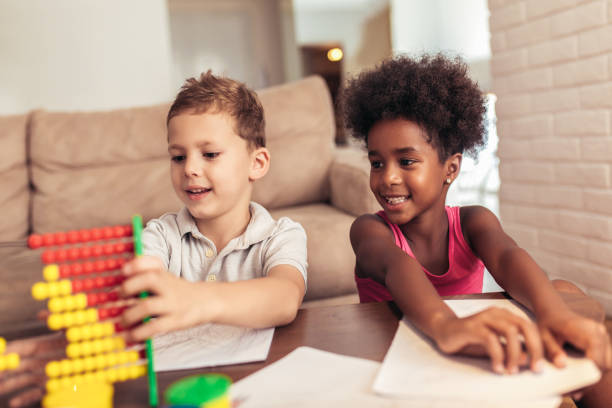istock Multiracial children drawing and using abacus at home 1007646076