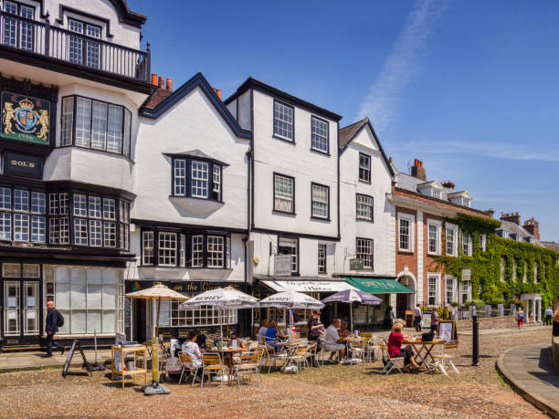 Cathedral Close Exeter UK 21 June 2017: Exeter, Devon, England, UK - People sitting outside coffee shops, including Mol's Coffee Shop,  in Cathedral Close on a sunny summer day. exeter england stock pictures, royalty-free photos & images