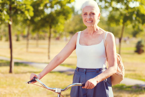 istock Active senior lady posing with bicycle in park 1007652804