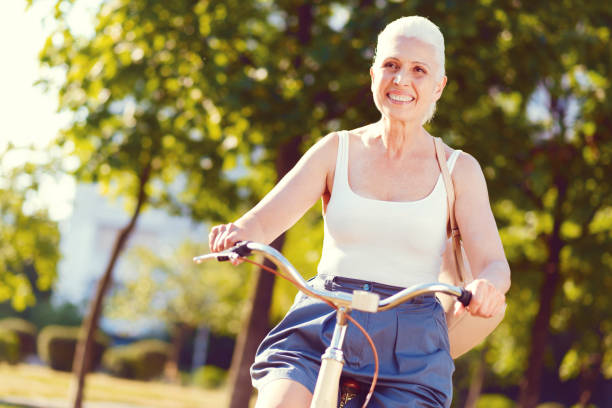 istock Radiant retired woman grinning broadly while bicycling 1007655606