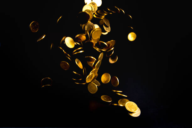 istock Falling gold coins money in dark background, business concept. 1007655962