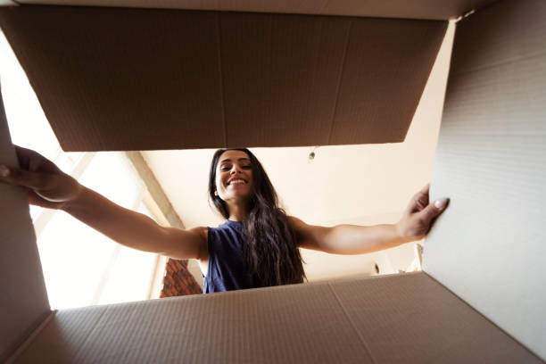 istock Smiling woman opening a carton box 1007665486
