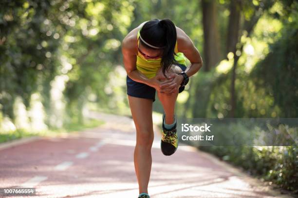 Female Runner Suffering With Pain On Sports Running Knee Injury Stock Photo - Download Image Now