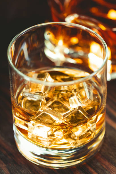 istock Whiskey with ice cubes in a glass ona wooden table. 1007672194
