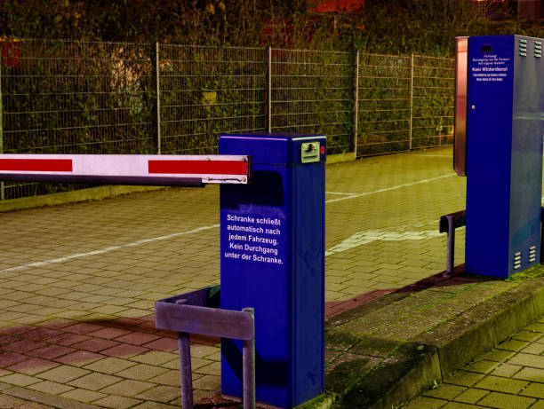 ドイツ語での碑文を持つ駐車場の障壁"シュランケ・シュリーストオートマティッチ・ナッハ・ジェデム・ファーゼグ"英語で「各車両の後にバリアが閉じる」 - nach ストックフォトと画像