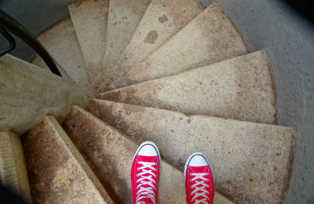 Red sneakers on spiral staircase when going downhill