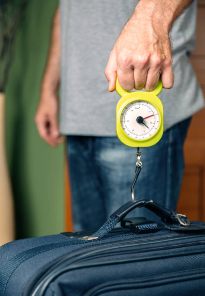 istock Man checking luggage weight with steelyard balance 1007678920