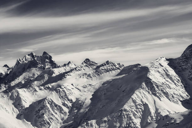 istock Black and white snowy sunlight mountains, view from ski slope 1007688820