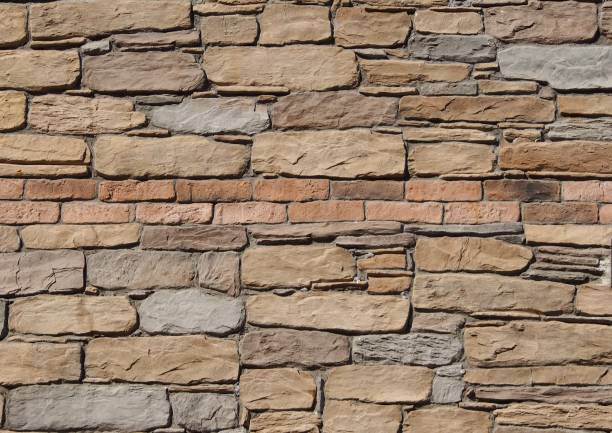 istock Rustic natural stones wall with two rows of bricks in the middle. 1007689738