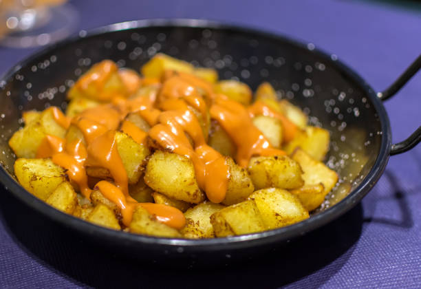 Patatas Bravas (Spanish Fried Potatoes) Patatas Bravas (Spanish Fried Potatoes) with spicy orange-colored salsa brava (brava sauce) or alioli (aioli). Patatas Bravas is a classic and very popular tapas dish served throughout Spain. patatas bravas stock pictures, royalty-free photos & images