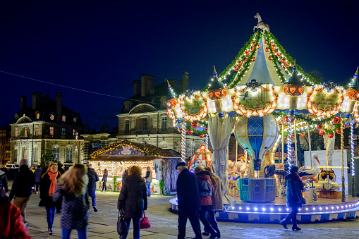 People at the Christmas market in Place du Château of Strasbourg, considered the capital of the historical region of Alsace. The city is the official seat of the European Parliament.