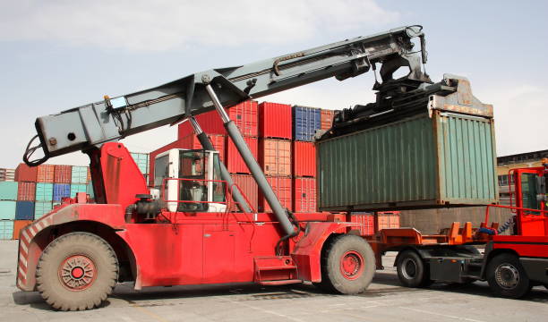 Reach stacker vehicle moving a container into a container terminal area stock photo