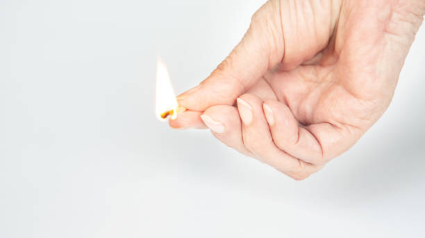 istock older womans hand holding a burning matchstick 1007698122