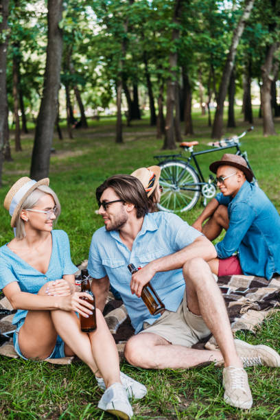 istock multiracial friends with beer resting in summer park 1007699084