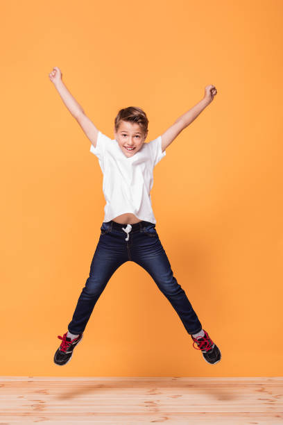 istock Little boy jumping in the studio, smiling. 1007701846