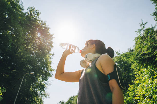 istock runner woman drinking water in hot summer day. copy space 1007702444