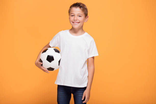 bravo ragazzino con palla da calcio. - soccer child indoors little boys foto e immagini stock