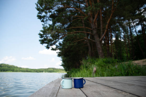 istock two metal cups with tea. river on background. summer time concept 1007704664